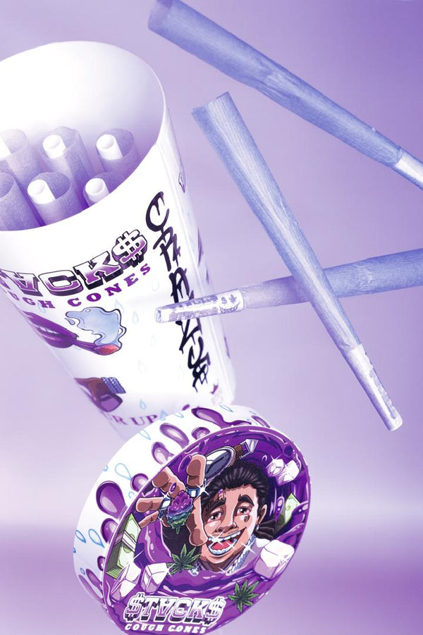 Artistic promotional photo of pre-rolled paper cones and a grinder with cartoon character artwork on a purple background. The image shows 'TORCH' branded rolling supplies including a container of pre-rolled cones and what appears to be a grinder with colorful cartoon artwork featuring a character design with money and leaf motifs.